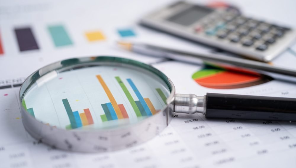 Magnifying glass on charts graphs paper. Financial development, Banking Account, Statistics, Investment Analytic research data economy, Stock exchange trading, Business office company meeting concept.